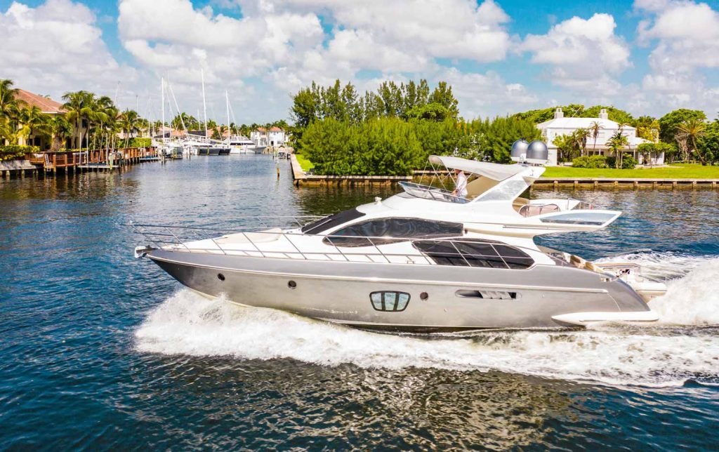 Azimut Yacht 57ft for rental in Miami Beach, Florida. The Silver Azimut Boat is driving on the water and waves around splashing.