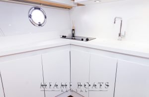 The kitchen area of the 46' Beneteau yacht. White kitchen cabinets and sink.