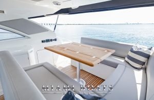 The aft deck of the 46' Beneteau yacht. White leather couch and wooden table.