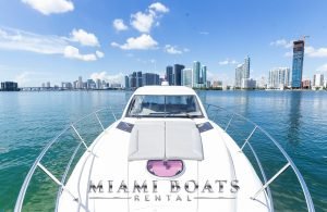 The bow of the 46' Beneteau yacht on the water. Miami Downtown on the background.