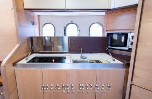 Kitchen of the 55' Astondoa yacht with wooden cabinets.