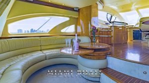 Main salon of the 55' Azimut yacht with the bottle of champagne and flowers on the table.