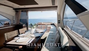 Dining area in the main salon of the 55' Azimut Spot luxury yacht with the ocean view on the background.