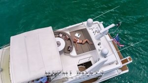 Girl laying on the sun pad at the Aft deck of the 70' Ferretti Flybridge luxury yacht.