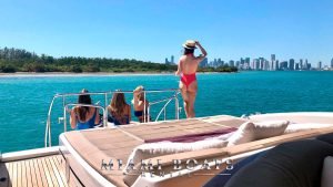 Girls observing Downtown Miami view from the back of the 72' Mangusta luxury yacht.
