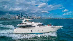 75' Aicon luxury yacht cruising on the water. Bridge and Miami Downtown on the background.