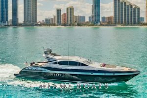 92' Mangusta luxury yacht cruising along the shore of Miami Downtown. View from the side.