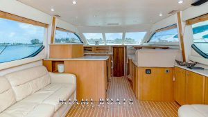 Image shows the cabin of the yacht with white cushions and light brown interior