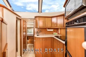 Kitchen area of the 45' Silverton yacht. Brown wood cabinets and marble countertop.