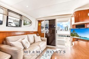 Living room of the 45' Silverton yacht. Leather couch and wooden interior with white ceiling.