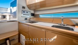 Kitchen of the 36 feet Canard yacht. Wooden cabinets and countertop with two sinks.