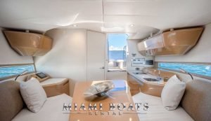 Living room of the 36 ft Canard Luxury yacht. Leather couches, wooden table and kitchen.