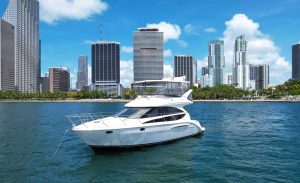 45 Meridian Yacht Flybridge Iris Miami, FL. Image of the white flybridge yacht on the water and with beautiful Downtown Miami at the back