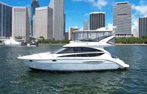 45ft Meridian Yacht Iris. Flybridge Yacht Rental in Miami Bay. on the background of the boat Downtown Miami and Brickell. Miami Beach and Miami area, South Florida.