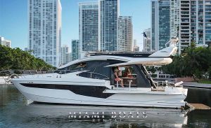 510 Galeon SKY Yacht in Miami. White Boat on the water and Miami Downtown in the background with a clear sky