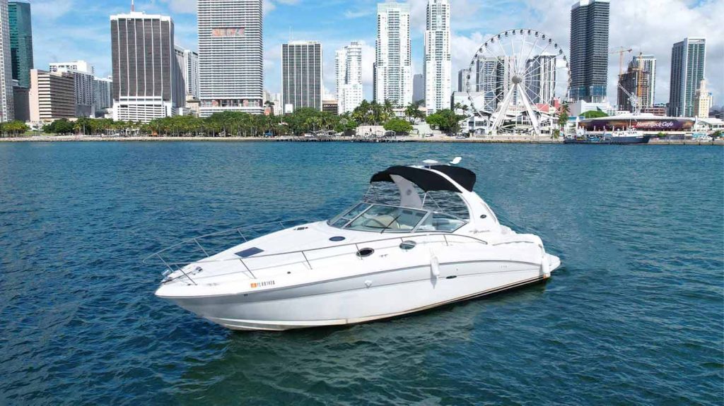 36 ft Sea Ray Boat Afina in Miami-Beach with background of Downtown Miami. SeaRay Yacht Sundancer or Boat Rental and Yacht Charter in Miami, FL.