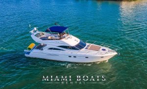 Yacht built Viking Princess 60ft in Miami, Florida. The boat driving on the water next to the one of Miami Islands. Flybridge Yacht with Miami Boats Rental Logo