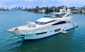 Super Yacht in Miami with the Jacuzzi on the bow. The 95 ft Dominator Yacht "Casual" is a white luxury yacht flybridge, that also includes a sunshade with cushions next to the Jacuzzi on the bow of the yacht.