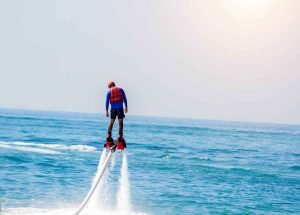 Man posing at new flyboard on the ocean in Miami. Things to do on vacations, enjoying summer in Miami Beach.