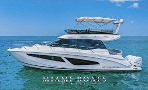 Yacht Charter experience with 45' Regal Yacht Aquarius. Image of the white yacht driving fat in Miami water.A magnificent image of a 45-foot Regal Flybridge Yacht available for rental in Miami, exhibiting its sleek design and luxurious features against the vibrant Miami backdrop.