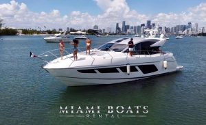Yacht Rental Miami. Sunseeker Yacht Predator 60ff. The Sport Boat on the water in Miami, and people are having fun in the front of the boat in good weather.