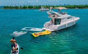 Sea Ray Yacht 46 feet Flybridge at sandbar with floating mat, raft, and paddle board. Available for rental in Miami by Miami Boats Rental.