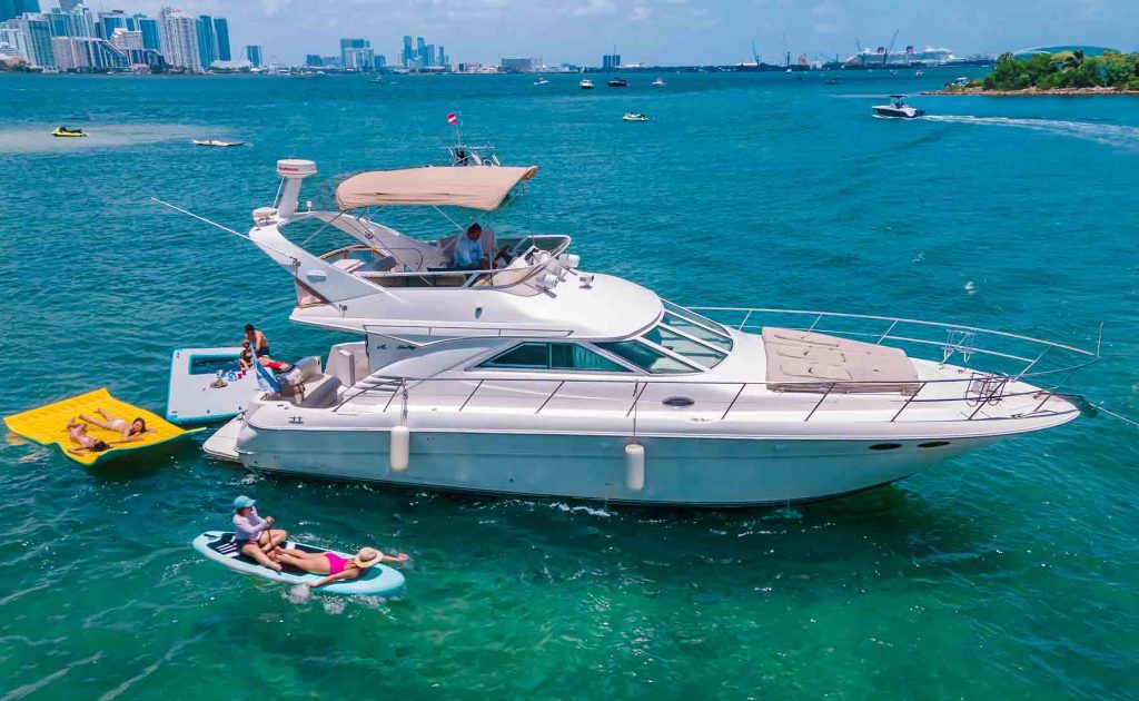 Sea Ray Yacht Sedan Flybridge 46 ft - the yacht in Miami Beach on the water and next to it girls on the paddle board