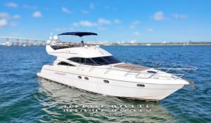 Luxury yacht rental in Miami – a stunning 60’ Viking yacht cruising on crystal-clear waters with a sleek white exterior, spacious sunbathing area, and a shaded flybridge. The yacht is perfect for private charters, special events, and luxury boat experiences. A scenic bridge and Miami skyline are visible in the background. “Miami Boats Rental” branding is displayed at the bottom.