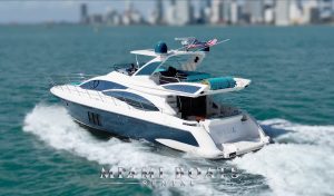 A beautiful luxury yacht, Azimut 60ft, cruising in Biscayne Bay in Miami with a beautiful downtown view in the background.