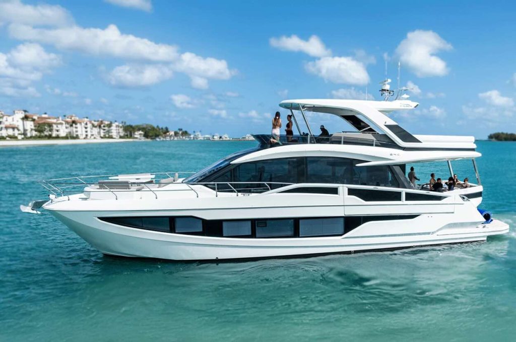 68’ Galeon Yacht ‘Seven Seas’ cruising in Miami’s turquoise bay with guests on the flybridge and aft deck.