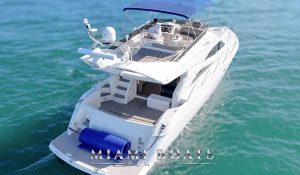 Luxury flybridge yacht rental in Miami – Aerial view of the 60ft Viking yacht in Miami, showcasing its spacious flybridge with a shaded seating area, a captain at the helm, and an open rear deck with a large floating mat for water activities. Ideal for private yacht charters and luxury boat rentals in Miami. “Miami Boats Rental” branding is displayed at the bottom.