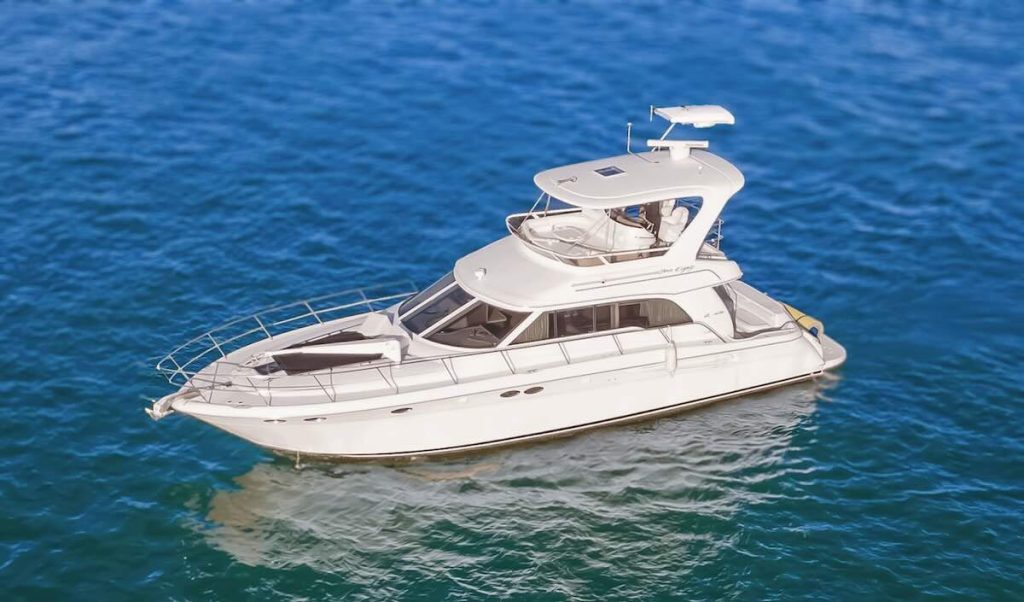 Aerial view of the 55’ Sea Ray Sedan ‘Island Itch’ yacht from Miami Boats Rental, showcasing its sleek white design and spacious flybridge. The yacht features a sun pad on the bow, large tinted windows, and a well-shaded upper helm station — floating gracefully over the vibrant blue waters of Miami, ideal for luxury charters and relaxing coastal escapes.