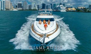 Image of four people sunbathing while the large 74' Sunseeker Yacht cruising them on the waters of Miami