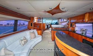 the saloon area of the Sunseeker yacht for rental in Miami with the bar area and large sofa