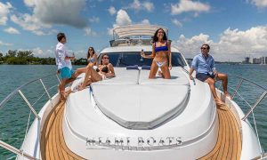 Friends enjoying the sunny day in Miami, drinking cocktails on a luxury yacht Sunseeker 74
