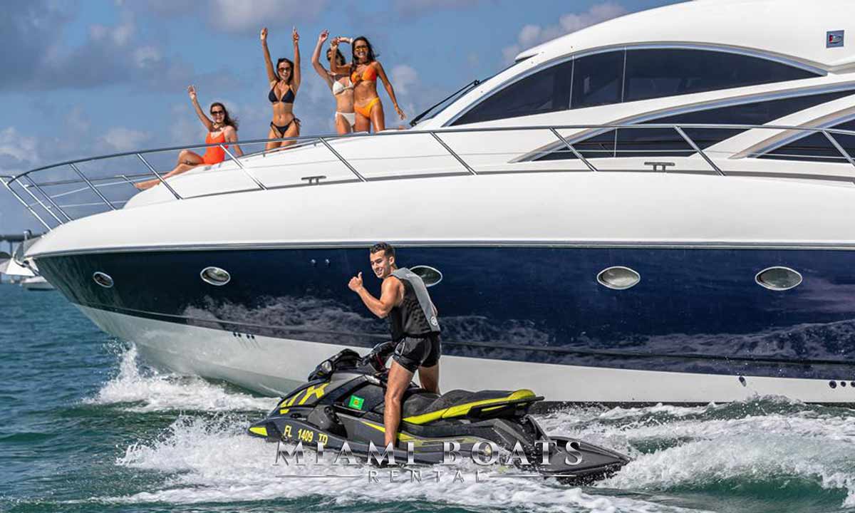 Image of the yacht from the water and next to the yacht driving a guy on Jet Ski