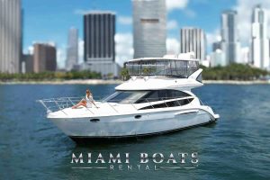 A 45’ Meridian yacht from Miami Boats Rental cruises in the foreground, with a woman lounging at the bow enjoying the Miami sun. The sleek white yacht features a spacious flybridge with full enclosures, set against a backdrop of Miami’s downtown skyline and turquoise waters — a perfect blend of luxury, relaxation, and iconic city views.
